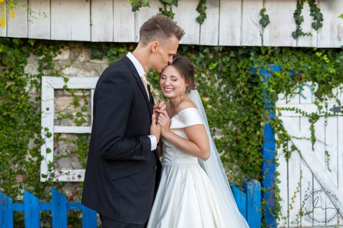 Novomanželé se líbají v sedle koní na lesní cestě